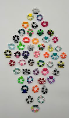 a pile of different colored earrings on a white surface with one being cut into the shape of a christmas tree