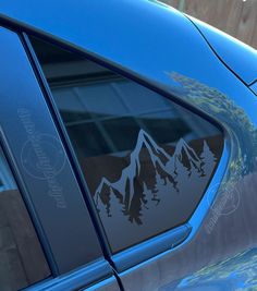 a blue car with mountains and trees decal on it