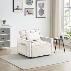 a living room with white furniture and pictures on the wall