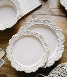 three white plates sitting on top of a wooden table next to a purse and money