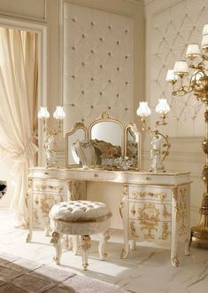 an ornate white dressing table with mirror and stool