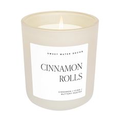 a glass candle with cinnamon rolls on the inside and white label that says sweet water decor