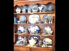 an old china cabinet filled with blue and white dishes