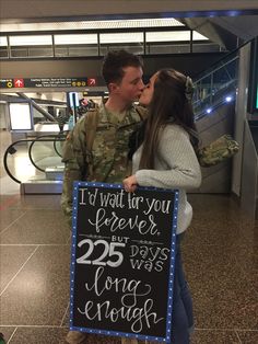 a man and woman kissing while holding a sign that says i'd wait for you forever but 25 days long enough