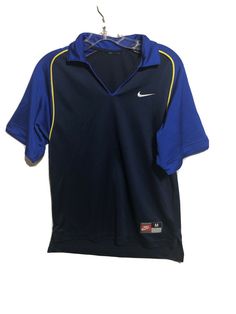 a blue and yellow nike shirt hanging on a clothes hanger in front of a white wall