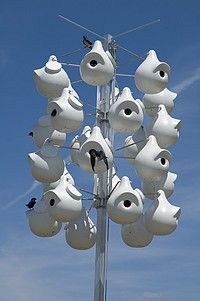 a tall pole with many white vases on it's sides and blue sky in the background