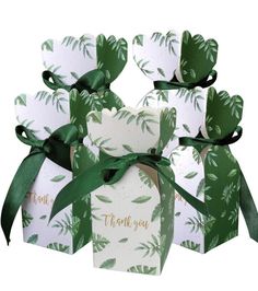 four boxes with green leaves and thank you written on the top, tied in ribbon