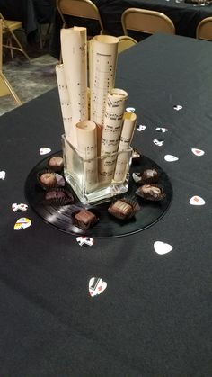 a black table topped with lots of chocolates and paper tubes on top of it