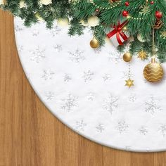 a white plate topped with christmas decorations on top of a wooden table covered in snow