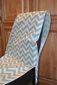 a blue and white chair covered in a chevroned fabric with a black frame