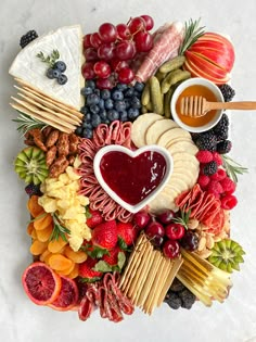 a platter filled with cheese, fruit and crackers