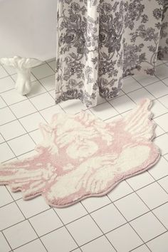 a pink and white rug sitting on top of a bathroom floor