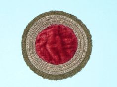 a close up of a red and beige area rug on a blue surface with a white background