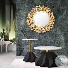 a room with two tables and a round mirror on the wall, in front of it