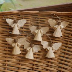 wooden angel ornaments are hanging on a wicker basket