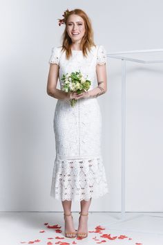 a woman in a white dress holding a bouquet of flowers