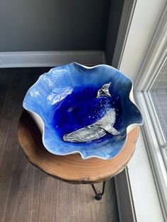 a blue bird bowl sitting on top of a wooden table