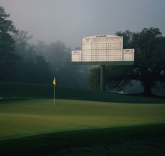 a foggy golf course with the scoreboard in the foreground