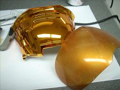 a yellow helmet sitting on top of a desk next to a computer mouse and keyboard