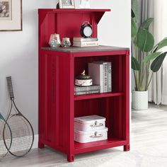 a red book shelf with books and tennis rackets