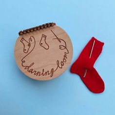 a wooden ornament with a pair of red socks next to it on a blue background