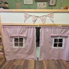 a doll house with pink curtains and white trimmings on the bottom bunk bed