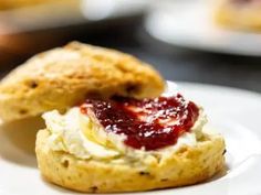 two scones with cream and jam on them