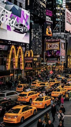 a busy city street filled with lots of yellow cabs