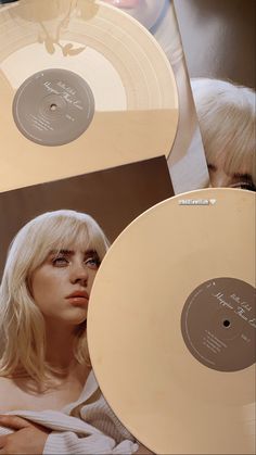 an image of a woman with blonde hair holding two records