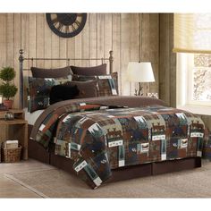 a bed in a bedroom with a brown and blue comforter set on top of it