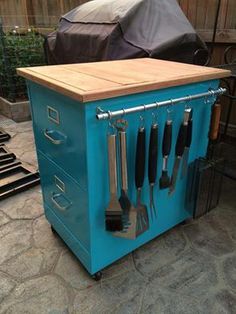 a blue tool box with utensils in it sitting on the ground next to a fence