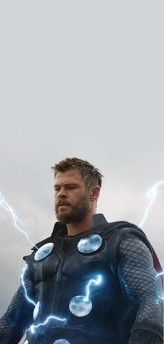 a man in a suit with lightning bolts on his chest and shoulders, standing against a cloudy sky