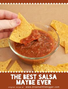 a person dipping salsa into tortilla chips