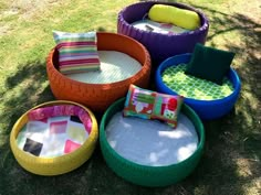 several different colored tires are sitting in the grass with pillows and throw pillows on them