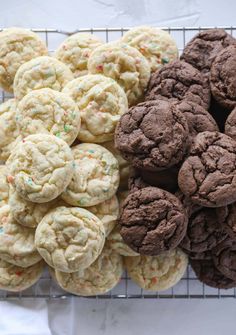 several cookies are on a cooling rack with sprinkles