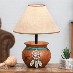 a wooden table with a lamp on top of it next to a potted plant