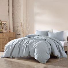 a bed with blue sheets and pillows in a room