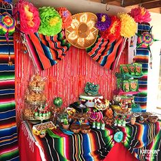 a mexican themed dessert table with lots of colorful decorations and tassels on it