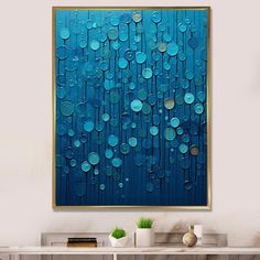 an abstract painting on the wall with blue circles and gold trimmings, hanging above a console table