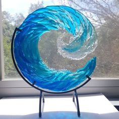 a blue glass sculpture sitting in front of a window