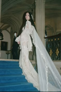 a woman in a wedding dress standing on some stairs