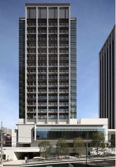 two tall buildings next to each other in front of a parking lot with cars parked on the street