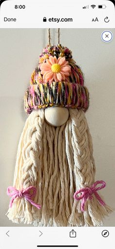 a white mannequin wearing a knitted hat with flowers on it