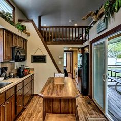 a kitchen with wooden cabinets and an open staircase leading up to the second floor area