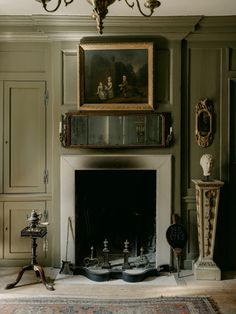 a living room with a fire place and paintings on the wall