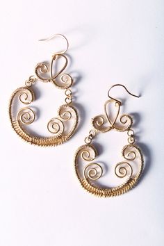 "This listing is for a pair of fabulous metalwork earrings. They dangle about 1.75\" long and are made from matte gold metalwork pendants, which I've dangled from matte gold ear wires. The pendants are made of two separate pieces, connected by gold jump rings. This separation keeps them from being too stiff so that they swing when you move." Elegant Wire Wrapped Wrap Earrings In Brass, Wire Wrapped Metal Chandelier Earrings For Gift, Elegant Gold Wire Wrapped Wrap Earrings, Gold Wire Wrapped Metal Earrings, Gold Metal Earrings With Wire Wrapped Detail, Gold Bohemian Wire Jewelry, Bohemian Gold Wire Jewelry, Gold Wire Dangle Earrings, Gold Brass Wrap Earrings For Pierced Ears