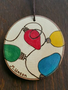 a wooden ornament with an image of a light bulb and the name mason on it