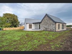 a stone house sitting on top of a lush green field