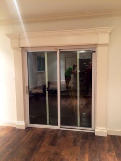 an empty room with sliding glass doors and hard wood flooring