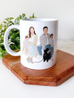 a white coffee mug with an image of people on it sitting on a wooden coaster